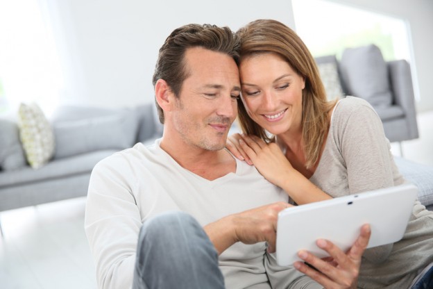 Couple using digital tablet at home